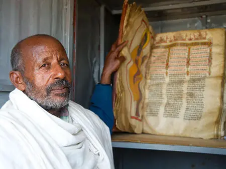  የዛዪይ ቄስ በቤተ መቅደሲይ ውስጥ ሆኑም ቅዱሳት መፀህፍቴይ ቲይሩ /የዛይ ቄስቤተ መቅደስ ውስጥ ቅዱሳት መፀሕፍትን ኢያዩ/A preist from the churches of Zay is showing the ancient holy scripts